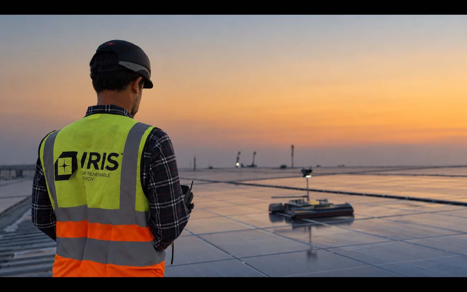 IRIS engineer overseeing robotic module cleaning on an industrial rooftop at dusk