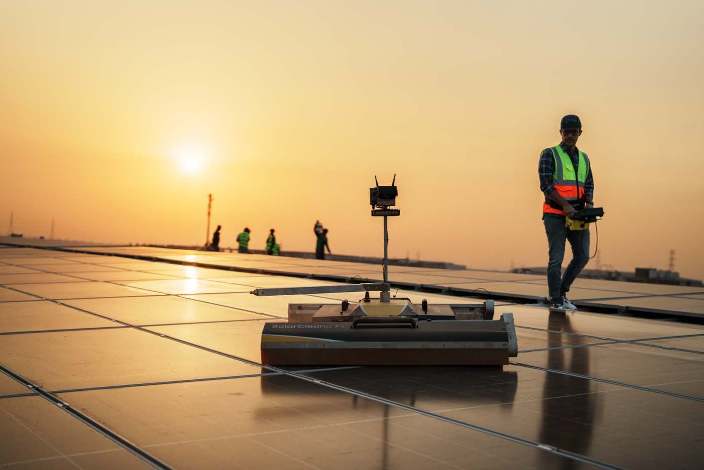 Robotic module cleaning on an industrial rooftop at dusk